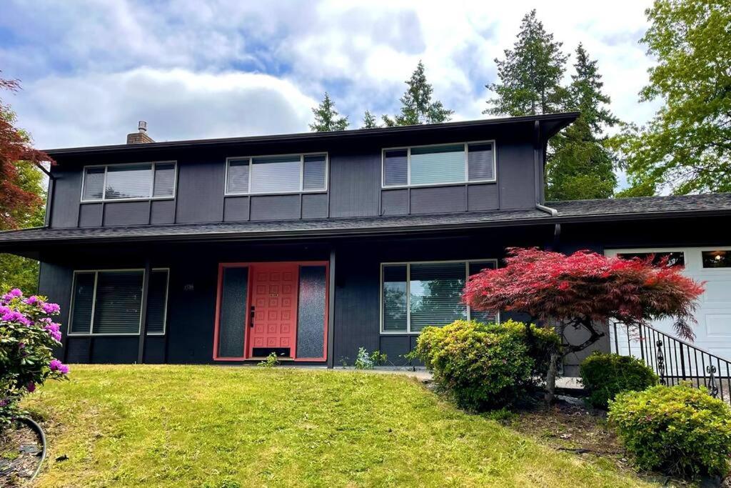 ein schwarzes Haus mit einer roten Tür und einem Hof in der Unterkunft 6BR Spacious-Bright-Modern in Eugene