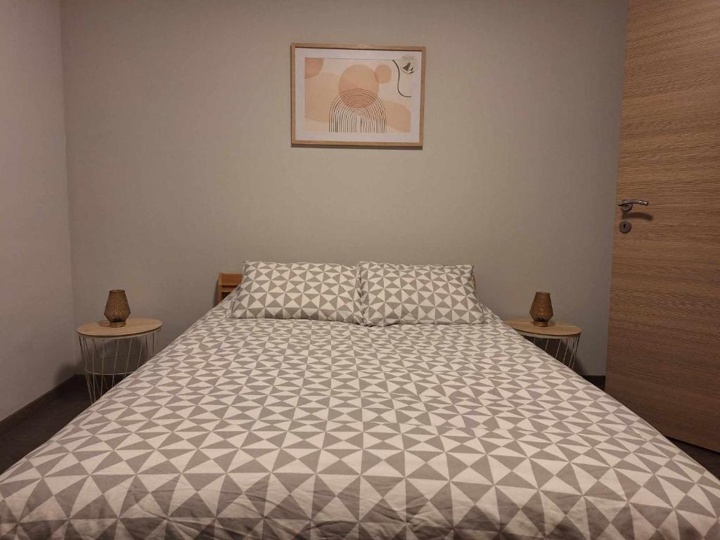 uma cama num quarto com duas mesas e uma foto em Résidence d'Angelo em Huy
