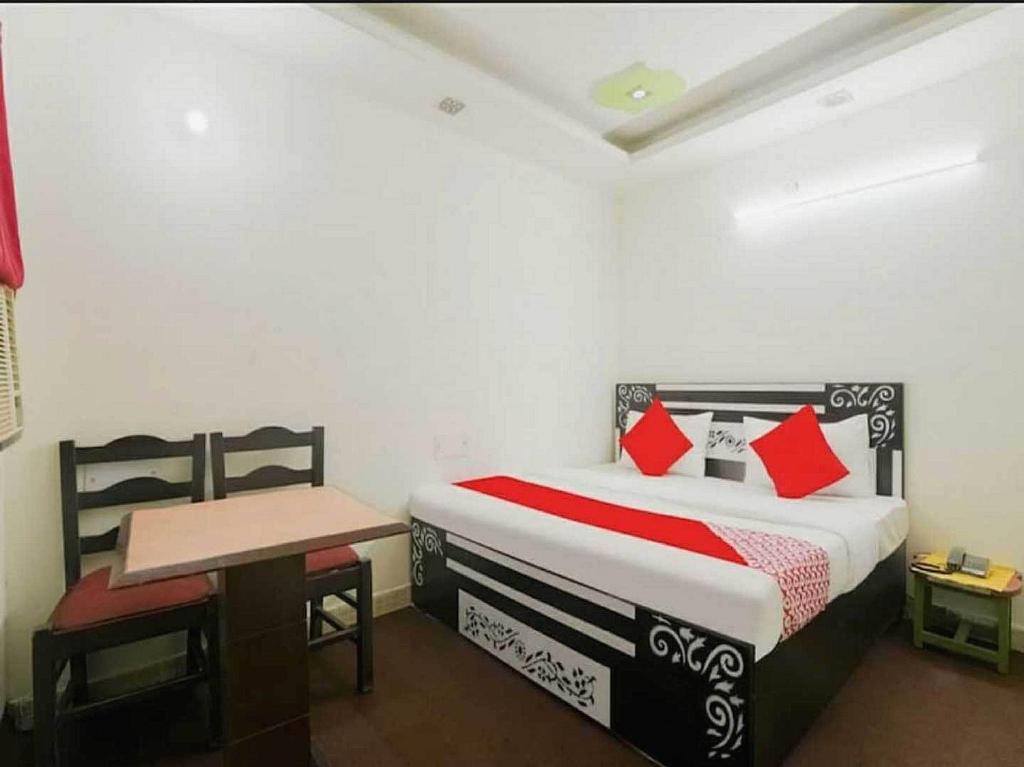 NajafgarhにあるOYO Hotel silver stoneのベッドルーム1室(ベッド1台、デスク、ベッド1台、テーブル付)