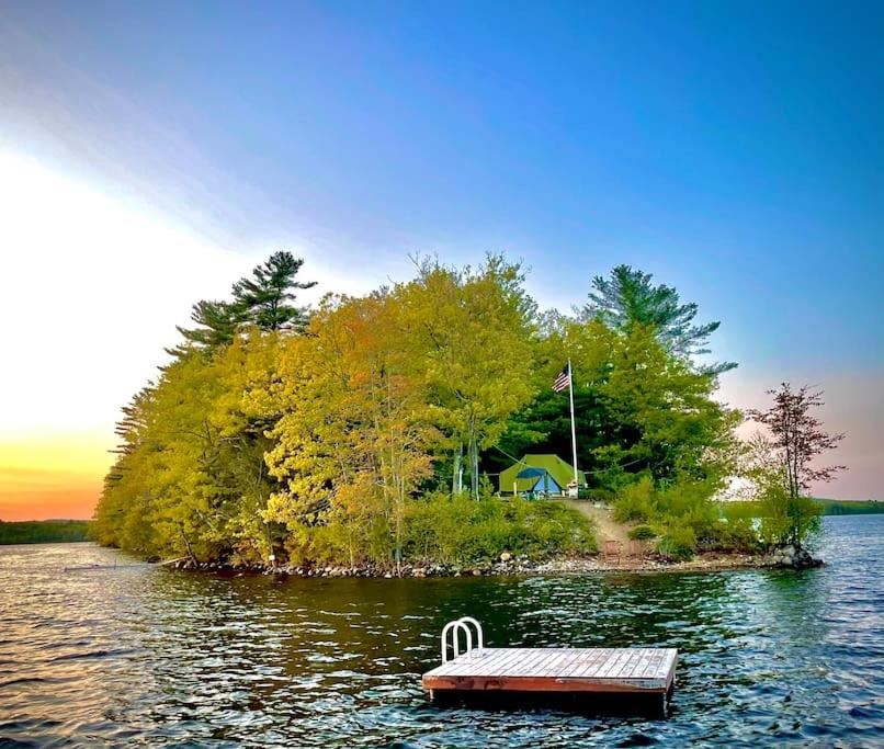 a small island with a bench in the middle of a lake at Island Tent Overlook in Maine in Monmouth