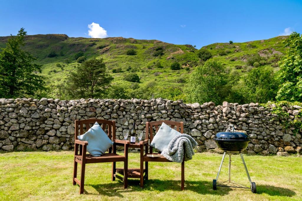 a grill and two chairs and a table and a grill at Bridge End Farm Cottages in Eskdale