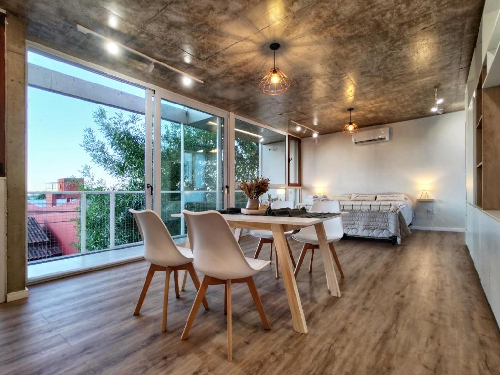 a living room with a table and chairs and a couch at Moderno y luminoso con vistas al ESTADIO ÚNICO in La Plata