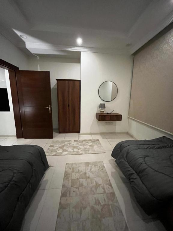 a bedroom with two beds and a mirror on the wall at شقة بغرفتين نوم وصالة بالمحمدية in Abḩur al Janūbīyah