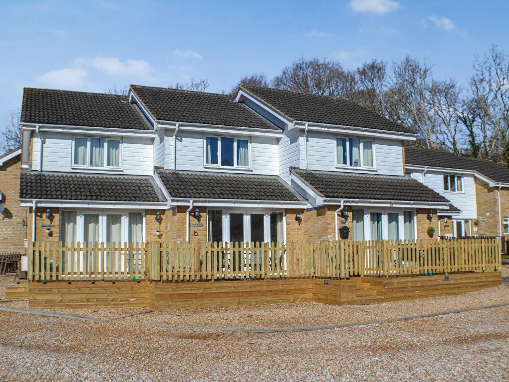 a house with a wooden fence in front of it at Totland in Wootton Bridge