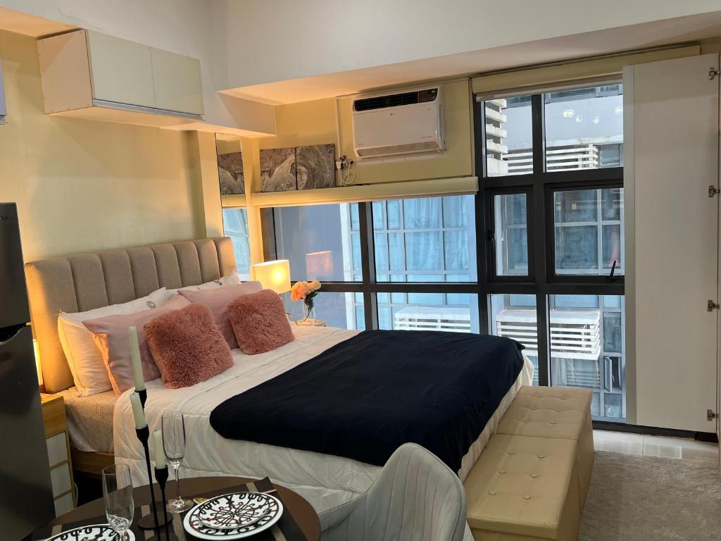 ein Schlafzimmer mit einem großen Bett und einem großen Fenster in der Unterkunft Viceroy Residences Chic Smart Home wifi Netflix in Manila