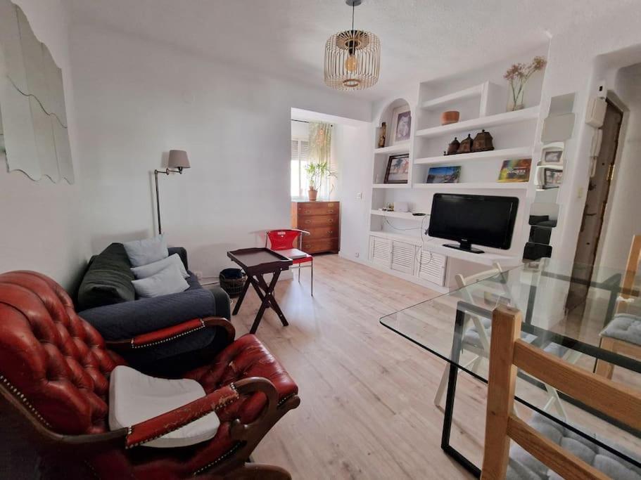 - un salon avec un canapé et une télévision dans l'établissement Porthos, bonito apartamento zona Puerta del Ángel, à Madrid