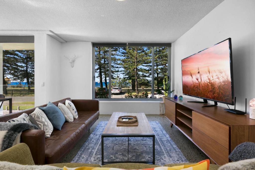 a living room with a large flat screen tv at Oceanfront 3-Bed with Beautiful Views in Burleigh in Gold Coast
