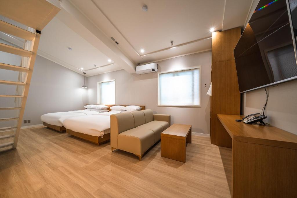 a bedroom with a bed and a tv and a couch at MONO HOTEL in Suwon