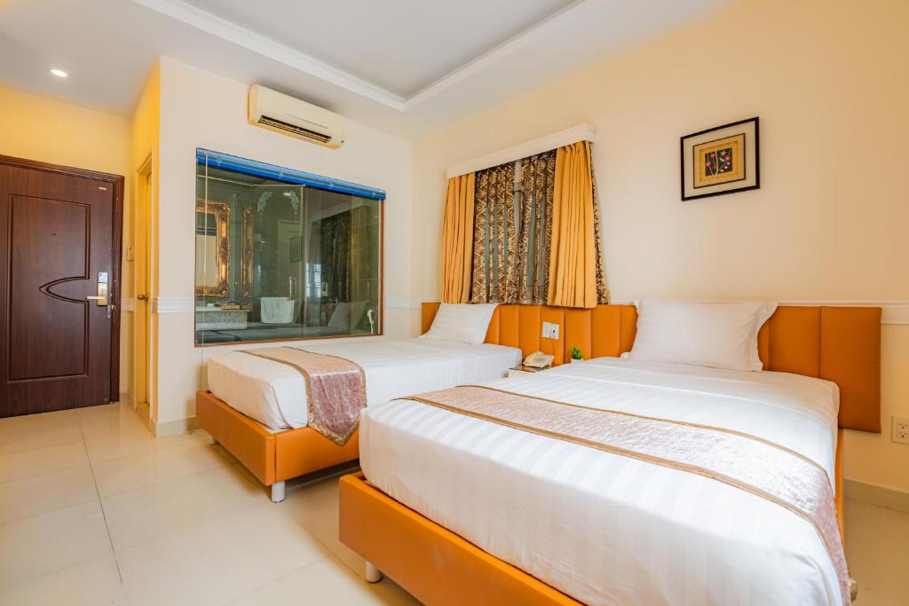 1 Schlafzimmer mit 2 Betten und einem Fenster in der Unterkunft Fortune 1127 - Central Hotel in Ho-Chi-Minh-Stadt