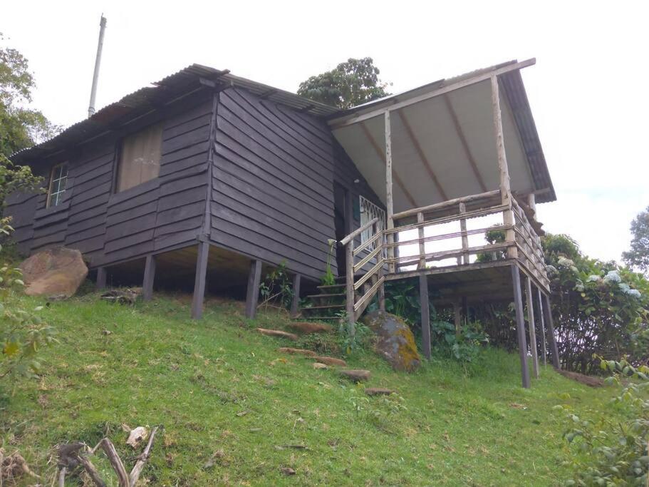 uma casa sentada no topo de uma colina em Cabaña Rural de Montaña en La Cima de Dota 