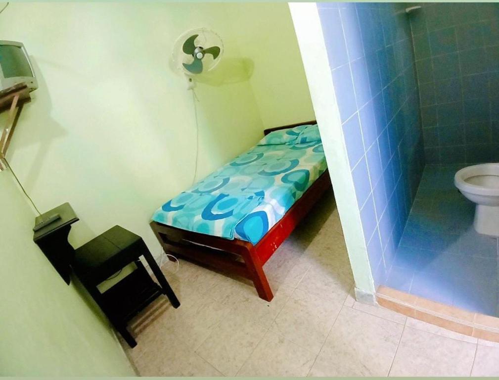 a bathroom with a bed and a shower and a toilet at Establecimiento luz y fer in San Vicente del CaguÃ¡n