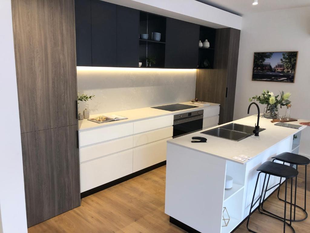 a kitchen with white cabinets and a white island at Funstay in Cheltenham