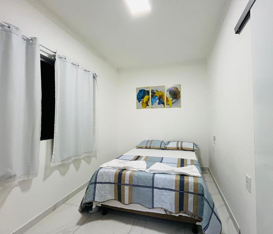 a white room with a bed and a window at NOVO APARTAMENTO Liz 1 in Porto Seguro