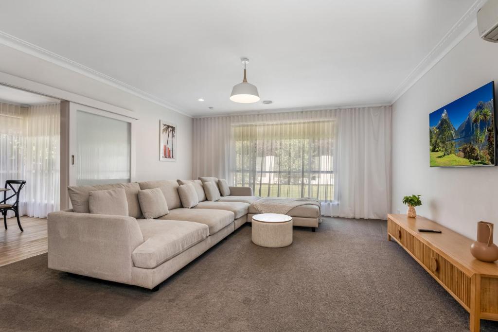 uma sala de estar com um sofá grande e uma mesa em Charming 3BR Home in Bendigo em Kennington