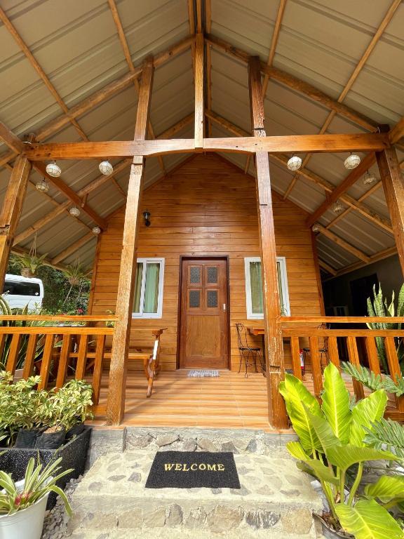 a front porch of a wooden cabin with a door at CABIN C at Bigang Munti Beach Resort in Bootin