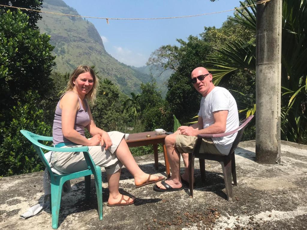 um homem e uma mulher sentados num banco em Green Mountain Villa em Ella