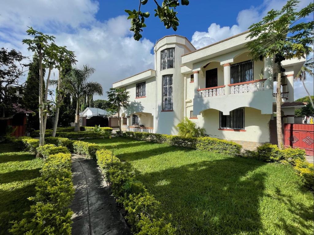 une maison avec une pelouse devant elle dans l'établissement Mudzini gardens - Luxury villa with a pool, à Mombasa