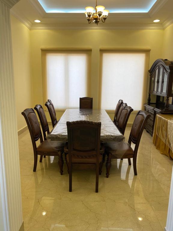 een eetkamer met een tafel en stoelen bij the beach house in Al Marfaʼ
