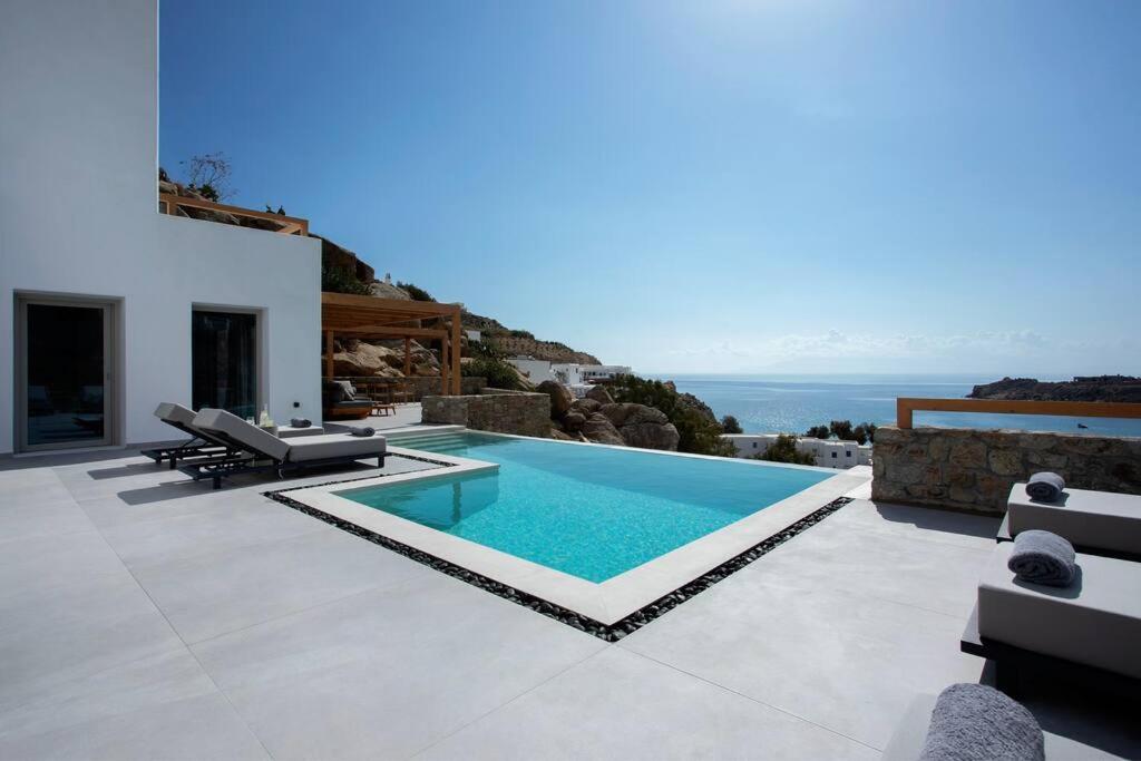 a villa with a swimming pool and a view of the ocean at Villa Mirage - Super Paradise beach in Mikonos