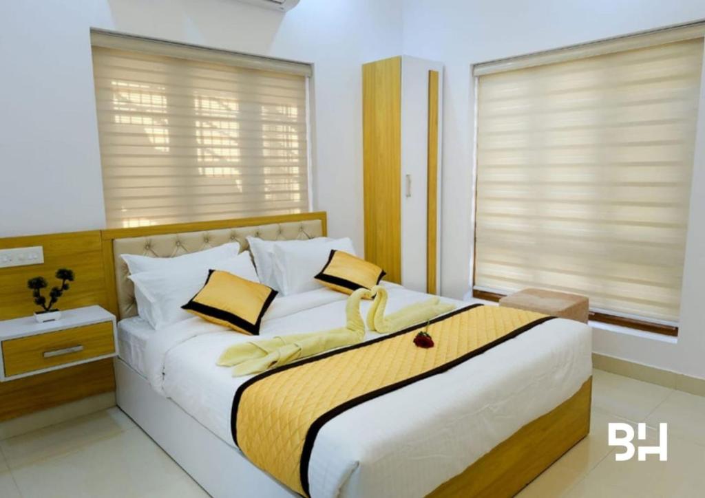 - une chambre dotée d'un grand lit avec des oreillers jaunes et blancs dans l'établissement Oceanpearl Kalapura Resort, à Ernakulam