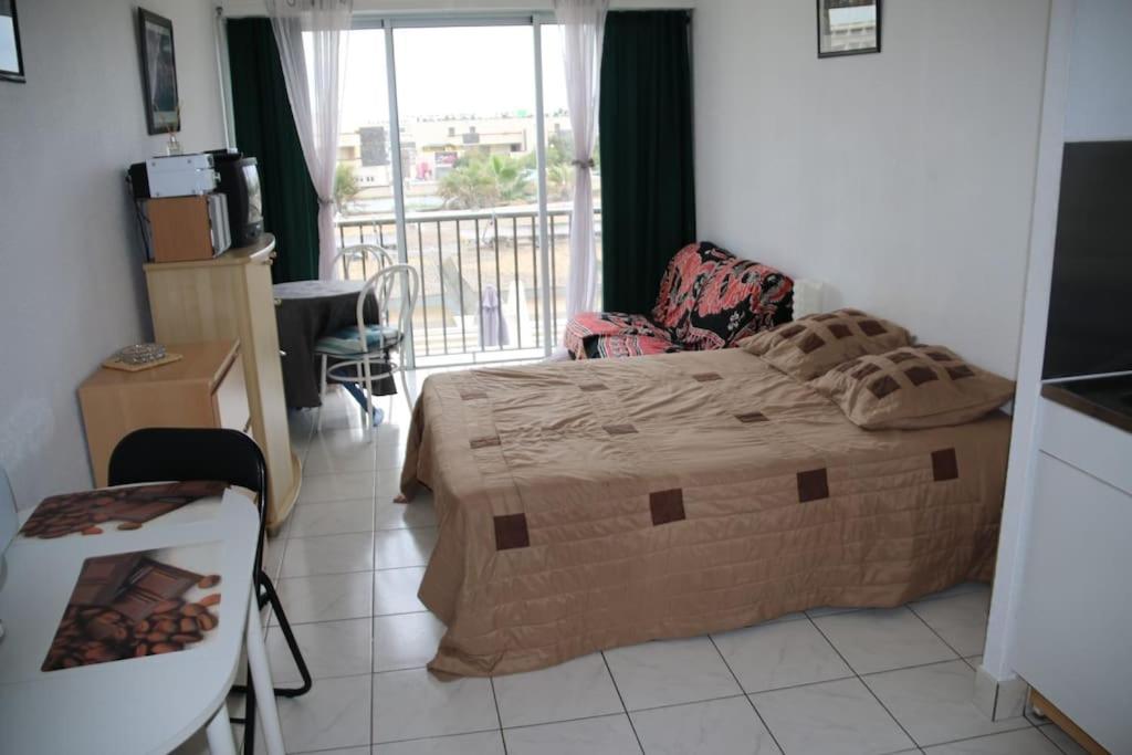 une chambre avec un grand lit et un balcon dans l'établissement Studio 46, Héliopolis FGH au village naturiste, au Cap d'Agde