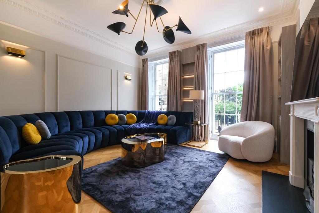 a living room with a blue couch and a blue rug at Luxurious Central 4BR Mansion 2 min from Hyde Park in London