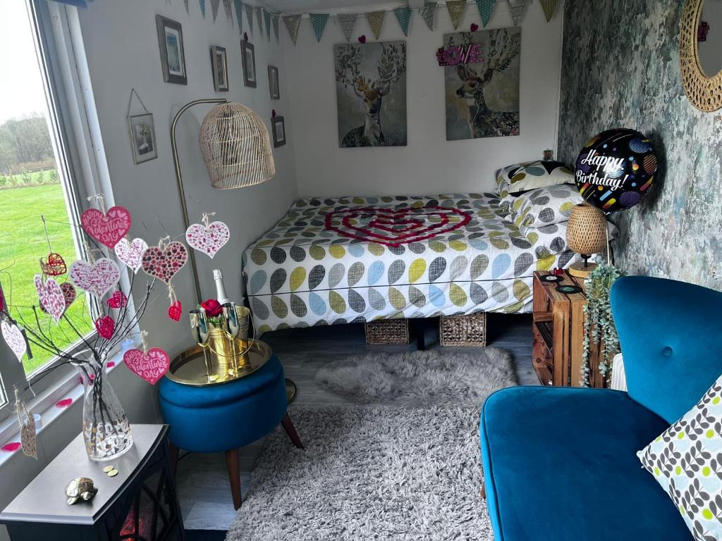 een slaapkamer met een bed en een blauwe stoel bij Bothy hut in Tring