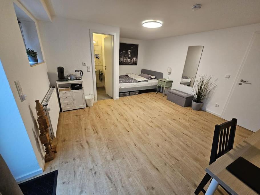 duży salon z łóżkiem i drewnianą podłogą w obiekcie Apartment Tanne w mieście Düsseldorf
