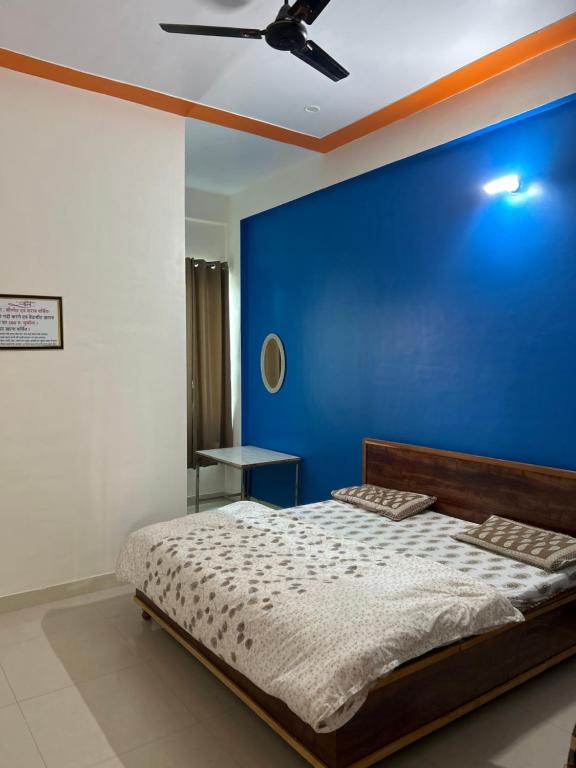 niebieska sypialnia z łóżkiem i wentylatorem sufitowym w obiekcie Prem Bhawan Guest House w mieście Khātu