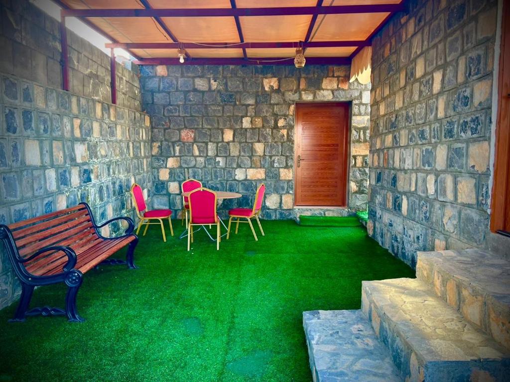 a patio with a bench and chairs and a table at بيت السلام bayt alsalam in Sa‘ab Banī Khamīs