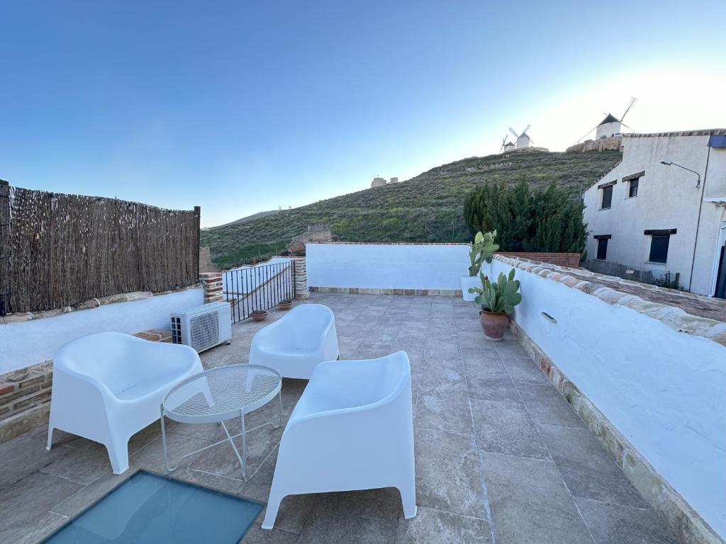 康斯埃古拉的住宿－Casa Entre Molinos，屋顶露台配有白色的椅子和桌子