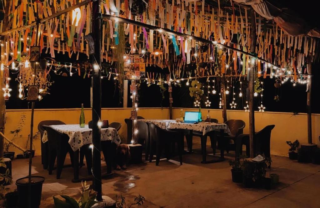 une salle à manger avec des tables, des lustres et des lumières dans l'établissement Bageecha B&B-Jal, à Alibaug