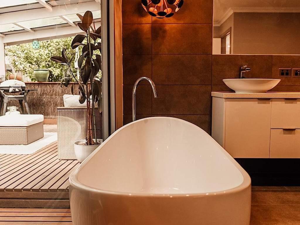 een badkamer met een ligbad en een wastafel bij Luxury Mountain Valley Villa in Mt Evelyn in Mount Evelyn