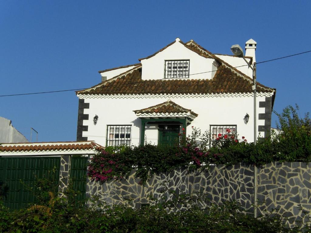 een wit huis met een hek ervoor bij El Lagar de Piedra in San Juan de la Rambla
