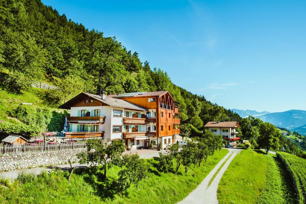 eine Gruppe von Gebäuden auf einem Hügel neben einer Straße in der Unterkunft Gasthof Hotel Wöhrmaurer in Feldthurns