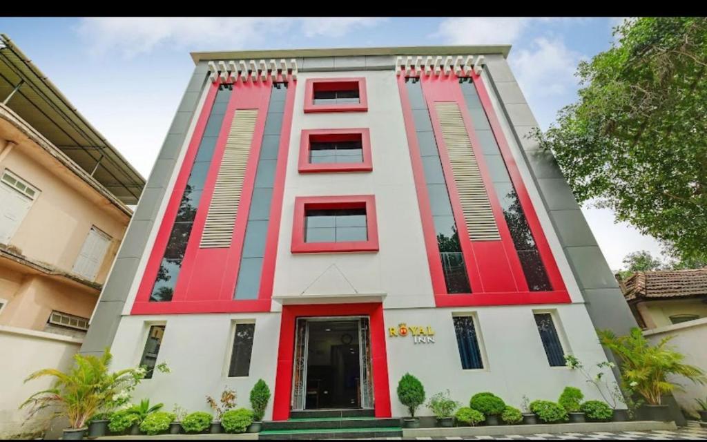 um edifício vermelho e branco com uma porta vermelha em ROYAL INN em Trivandrum