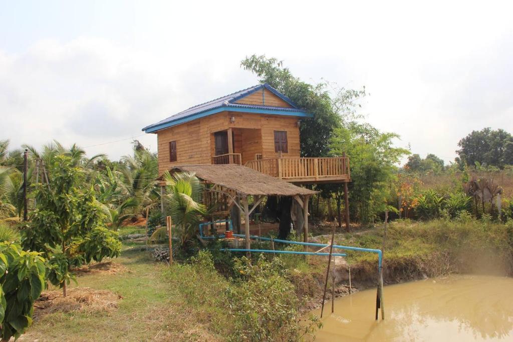 a house with a deck on the side of a river at Kampot CoCo Homestays in Phumĭ Bœ̆ng Preăh (1)