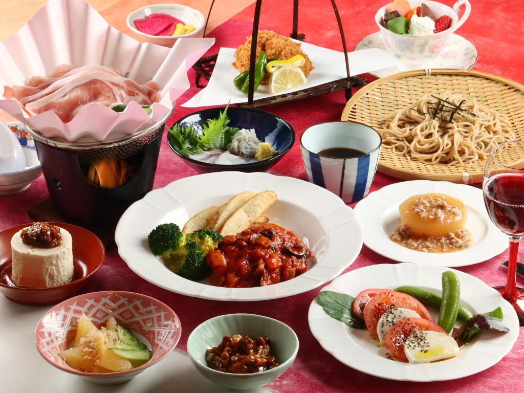 a table with plates of food on a red table at リゾートハウス秋桜 in Ōtaki
