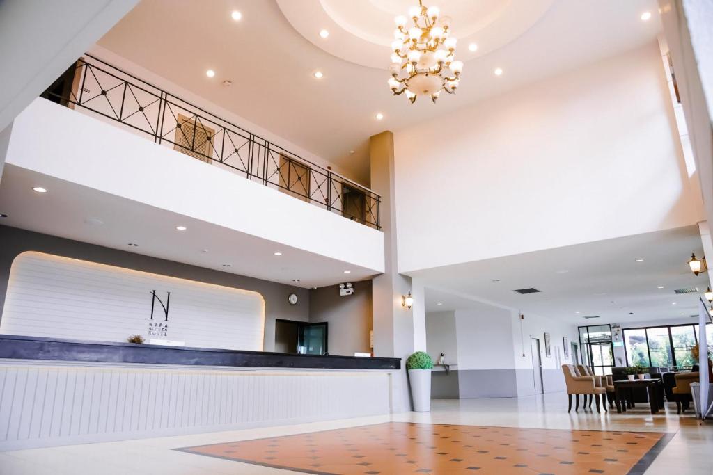 a large lobby with a reception desk and a staircase at Nipa Garden Hotel in Surat Thani