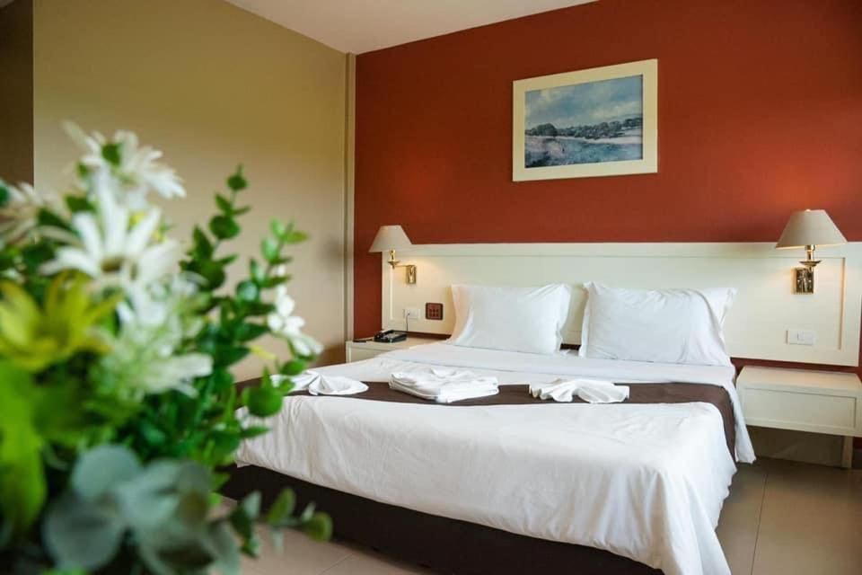 Un pat sau paturi într-o cameră la Nipa Garden Hotel
