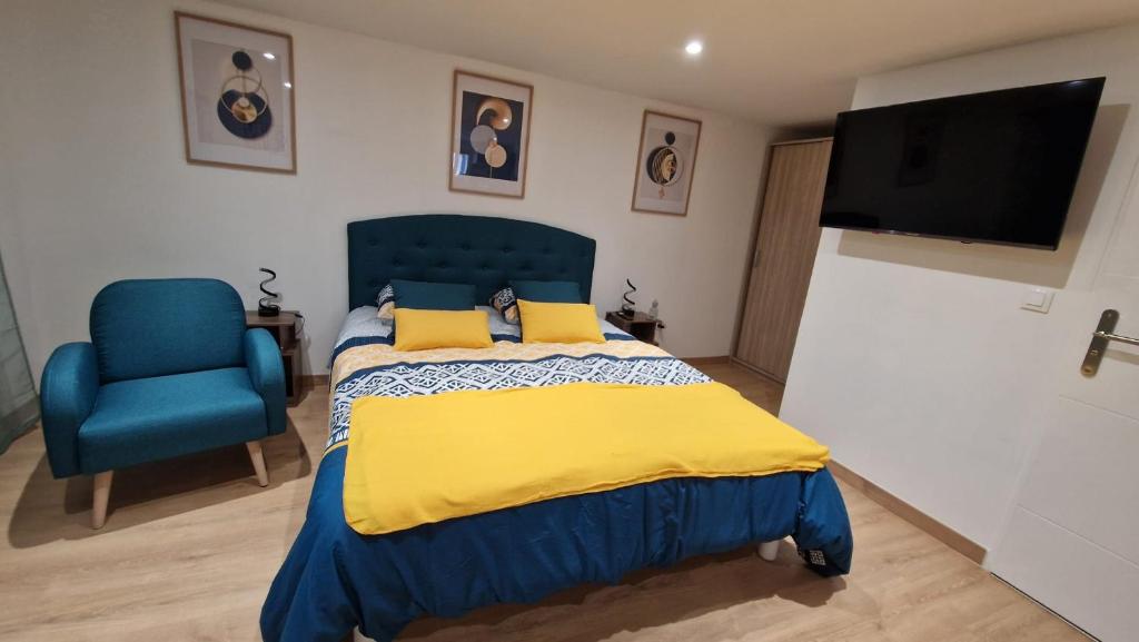 una camera con un letto blu e una sedia blu di maison neuve - le laos - a Les Ageux