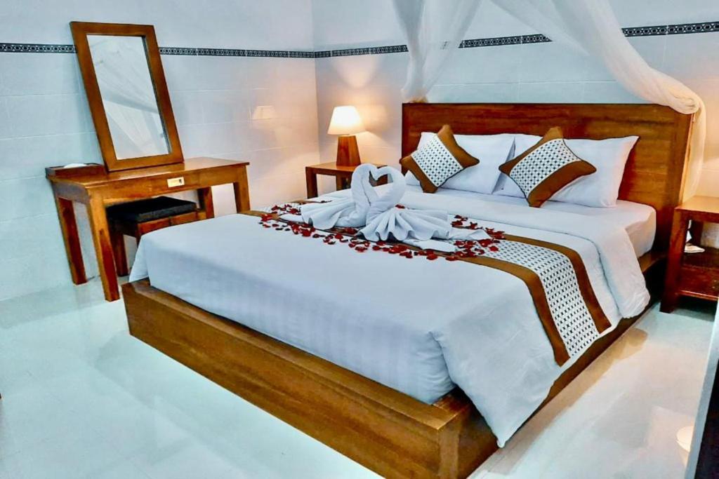 een slaapkamer met een groot wit bed met bloemen erop bij Serene Picturesque Villa Near Monkey Forest in Mambat