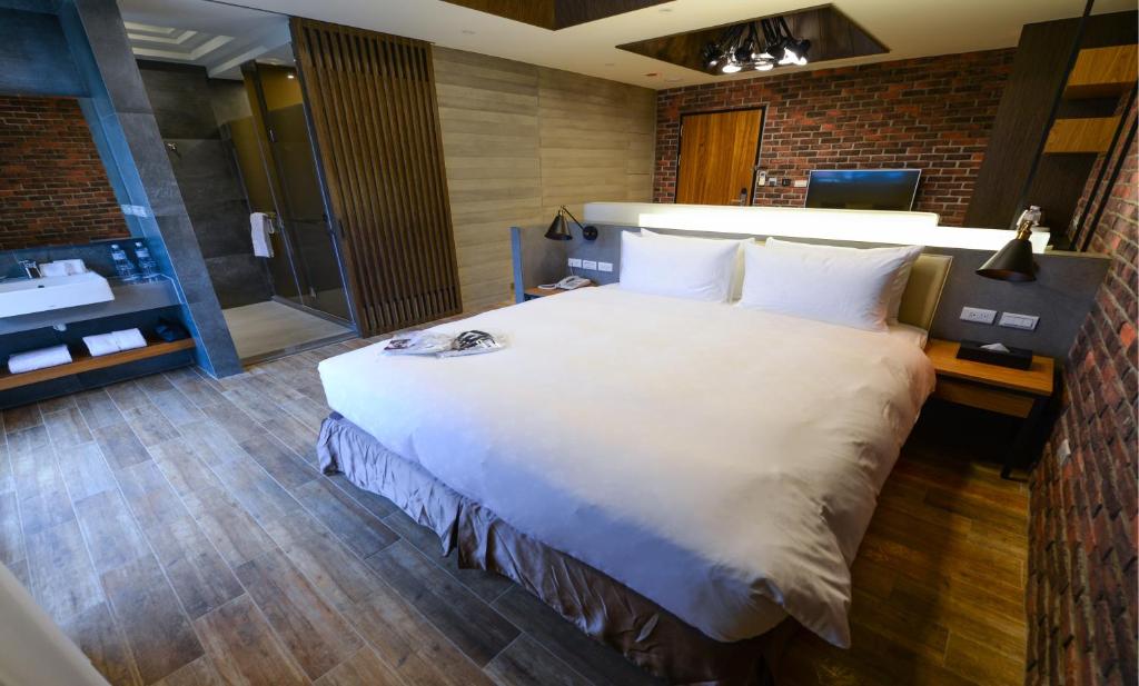 a bedroom with a large white bed and a bathroom at Kenting 4 Sisters Villa in Eluan