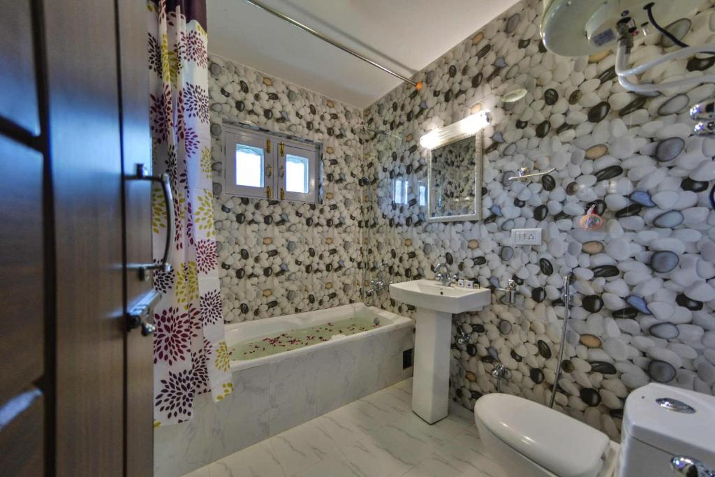 a bathroom with a tub and a sink and a toilet at hotel pearl continental in Srinagar