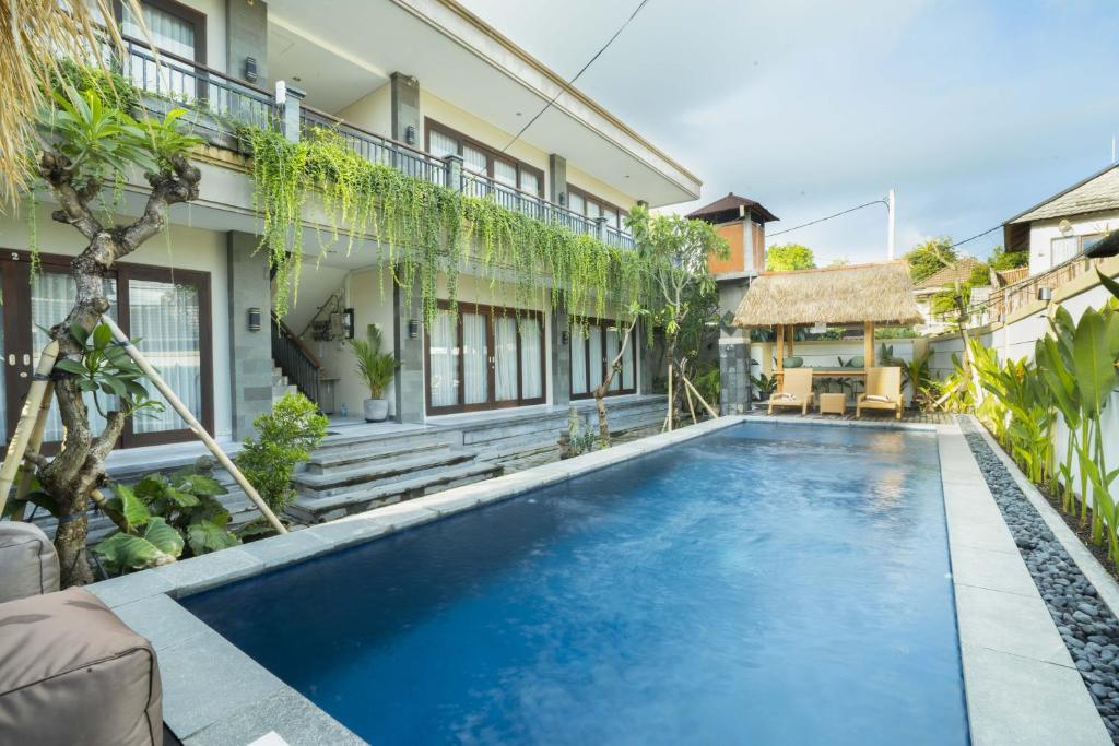 an image of a swimming pool in front of a house at Sleepwell Seminyak in Seminyak