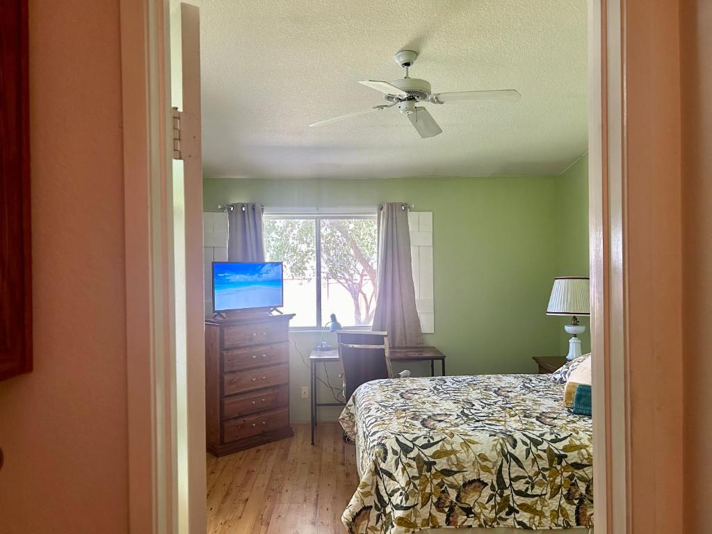 a bedroom with a bed and a desk with a television at Countryside comfort Suite with private bathroom in Hemet