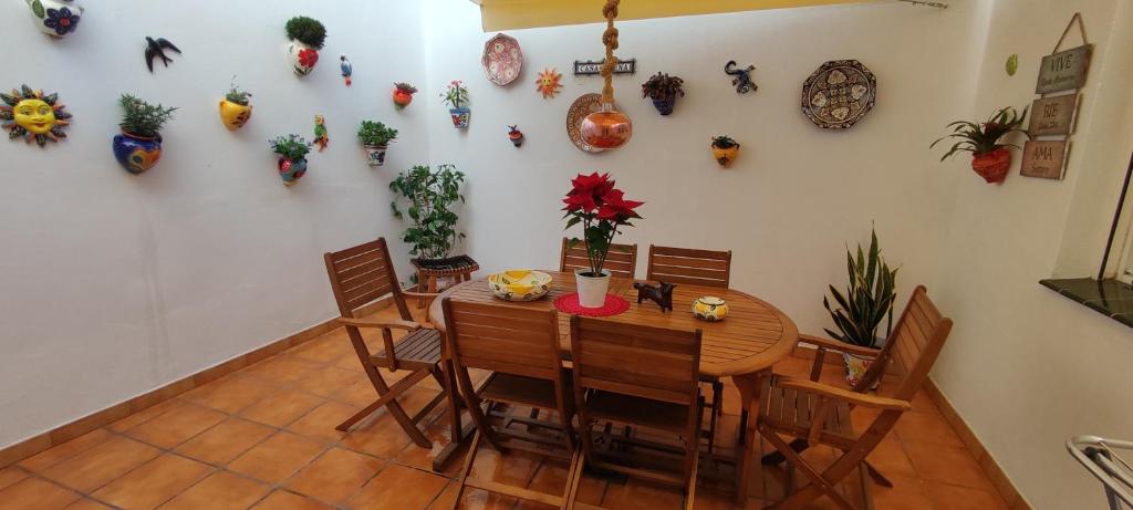 ein Esszimmer mit einem Tisch, Stühlen und Topfpflanzen in der Unterkunft Casa Elena in Fuengirola
