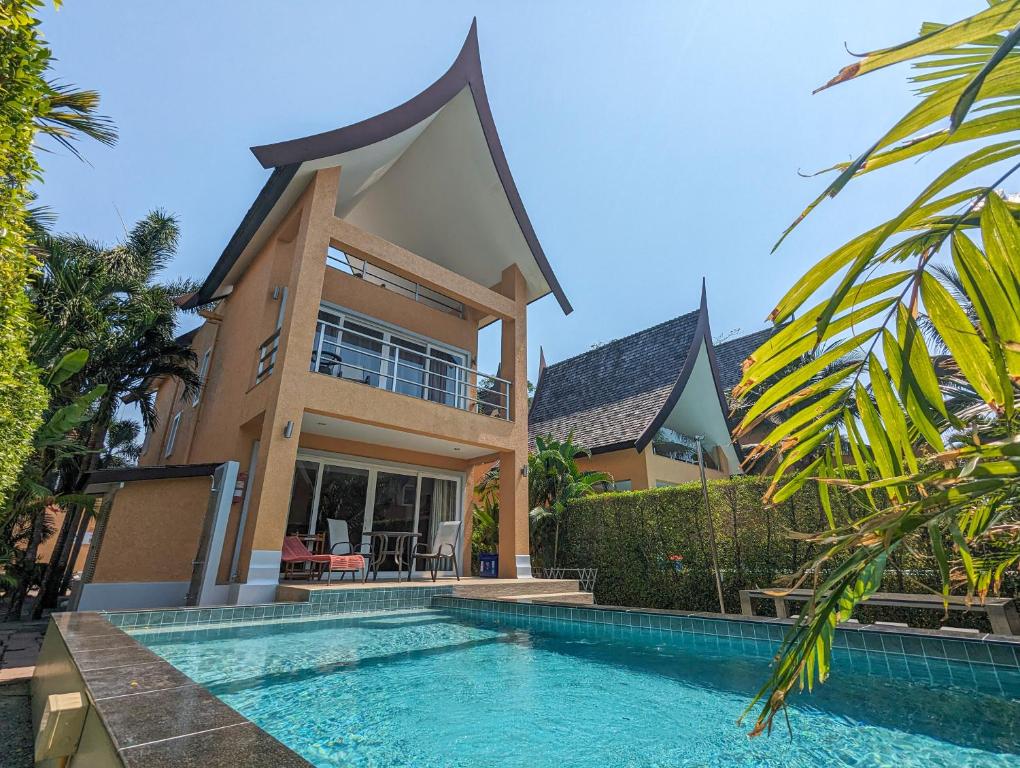 une maison avec une piscine en face d'une maison dans l'établissement Blue Moon Pool Villa, à Trat