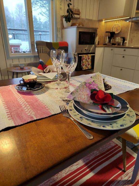 a table with plates and wine glasses on it at Mummon Mökki in Lokka