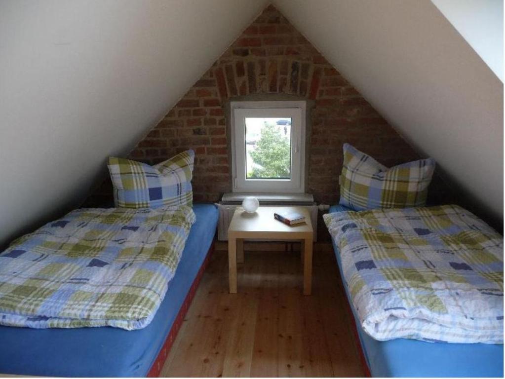 1 dormitorio en el ático con 2 camas y ventana en Ferienwohnung Ida, en Ahlbeck
